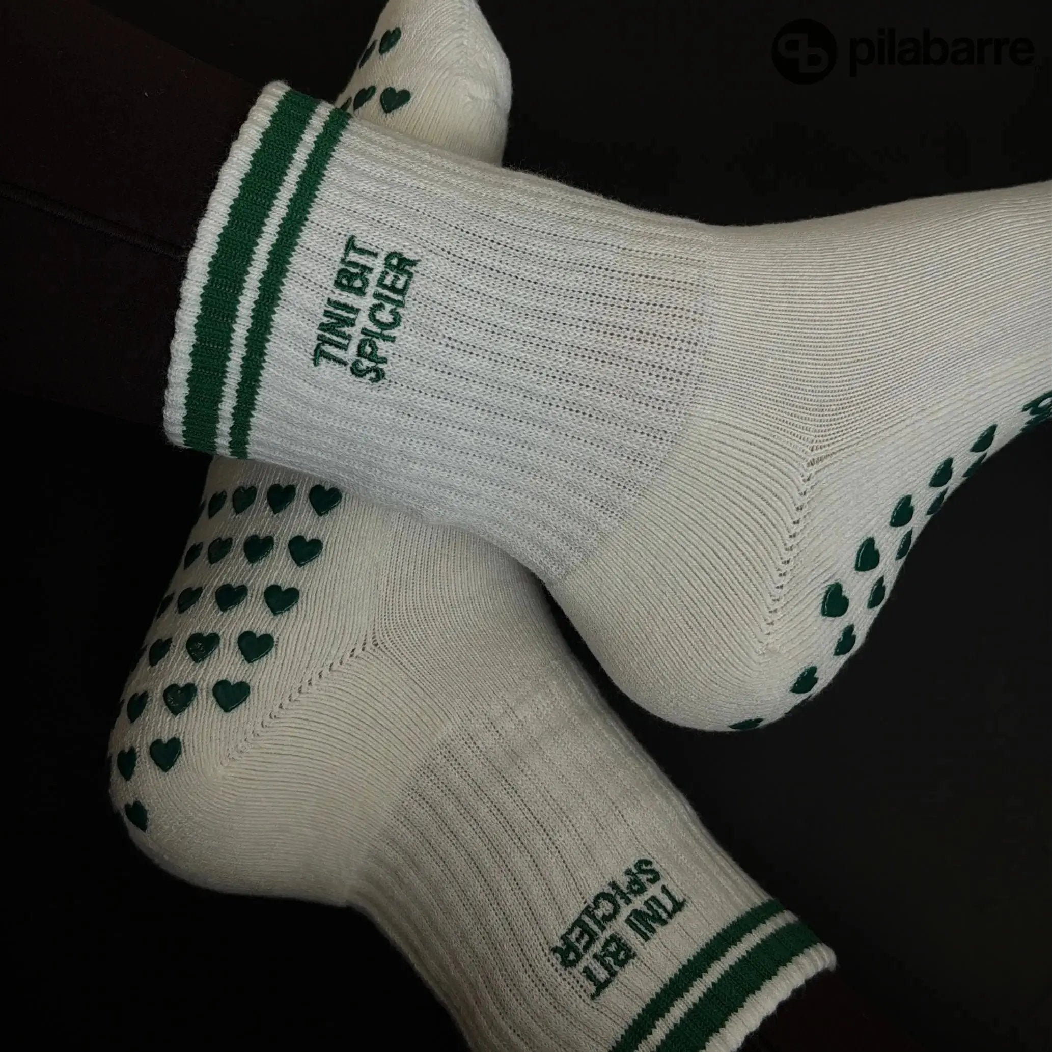 Cream socks with green accents and heart patterns on a black background