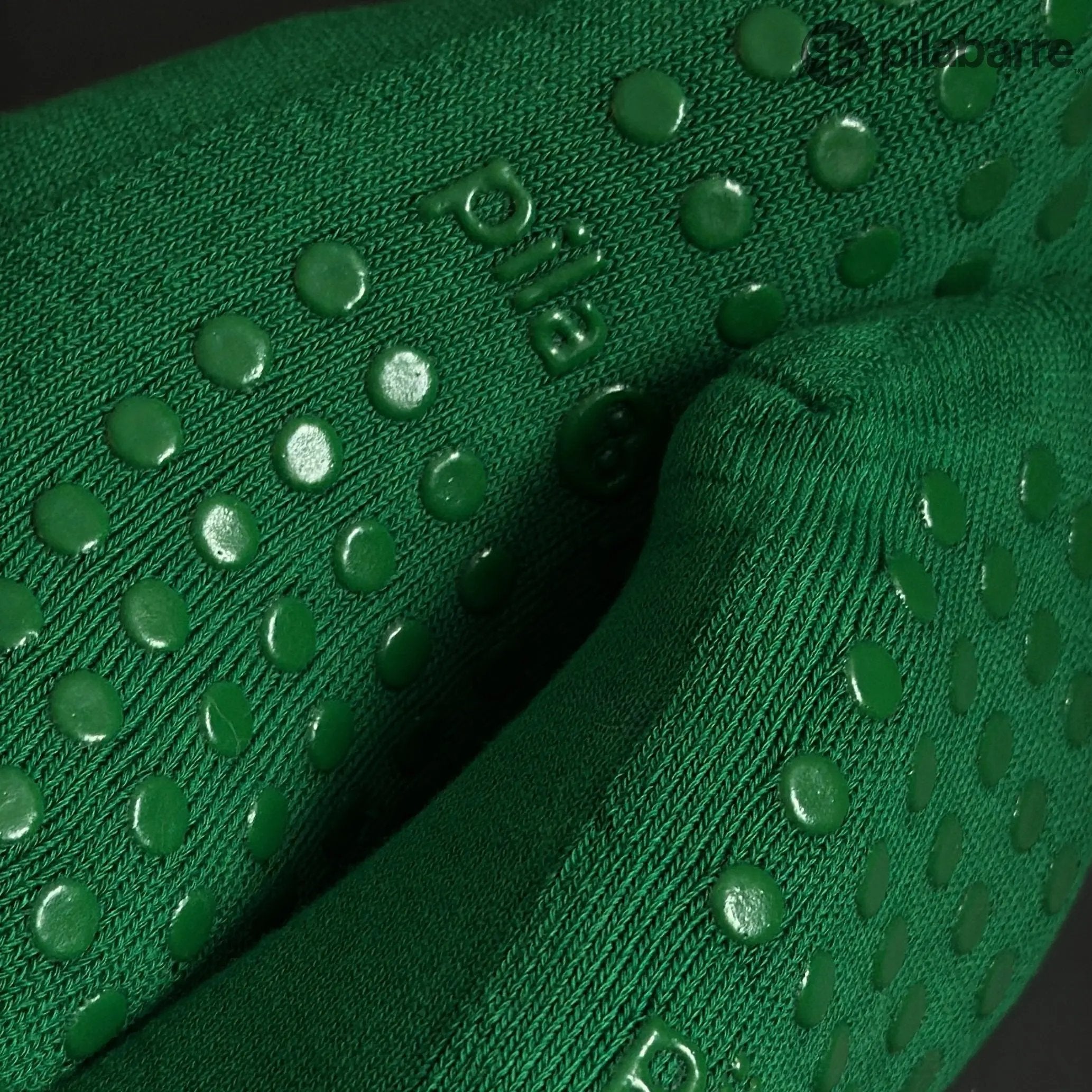 Close-up of green Grip socks with pilabarre logo.