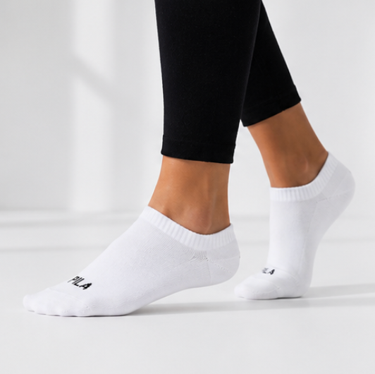 White ankle socks worn with black leggings on a light gray background