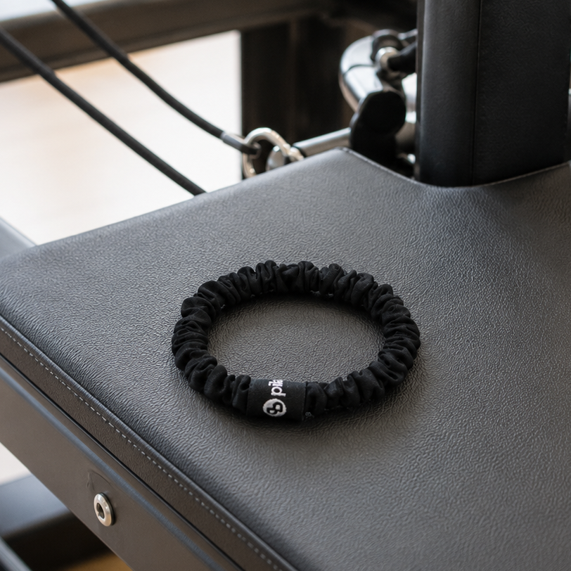 Black scrunchie on a reformer with a blurred background