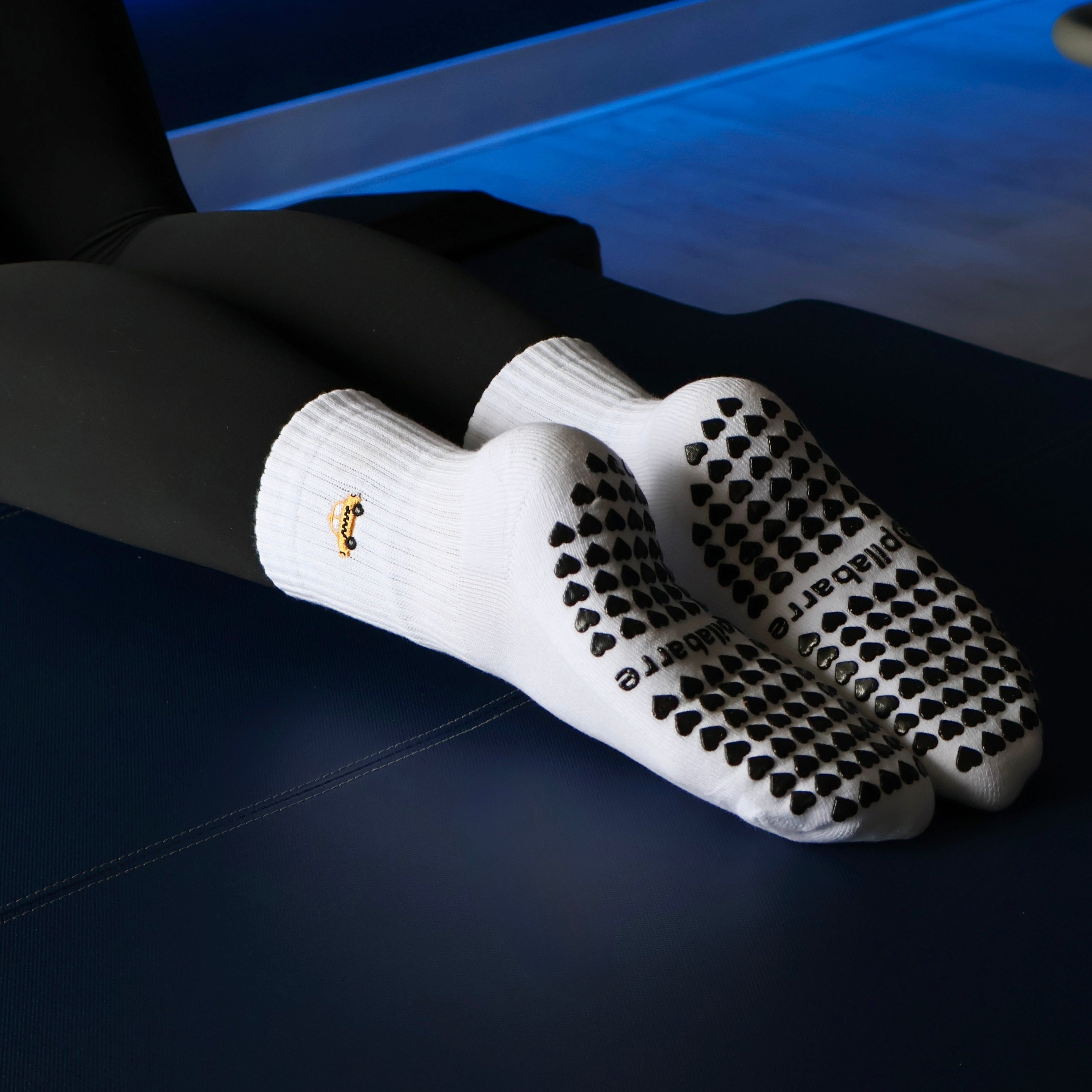 white grip socks on a reformer with a taxi and heart grips at the bottom